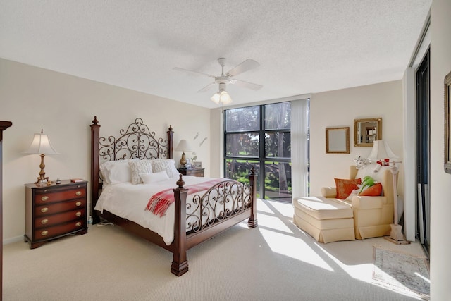 bedroom featuring ceiling fan, light colored carpet, a textured ceiling, and access to outside