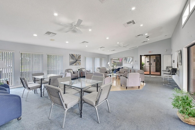 dining room with light carpet, ceiling fan, a textured ceiling, and high vaulted ceiling