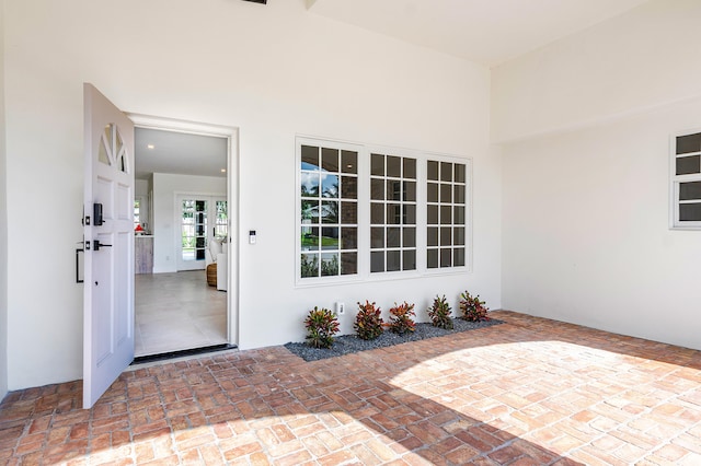 view of exterior entry with a patio area