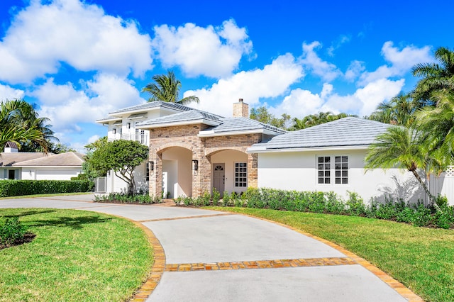 mediterranean / spanish-style house with a front yard