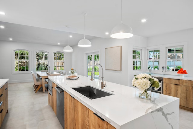 kitchen with a large island, a wealth of natural light, sink, and pendant lighting