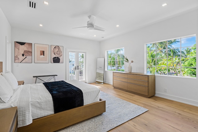 bedroom featuring access to outside, french doors, light hardwood / wood-style floors, and ceiling fan