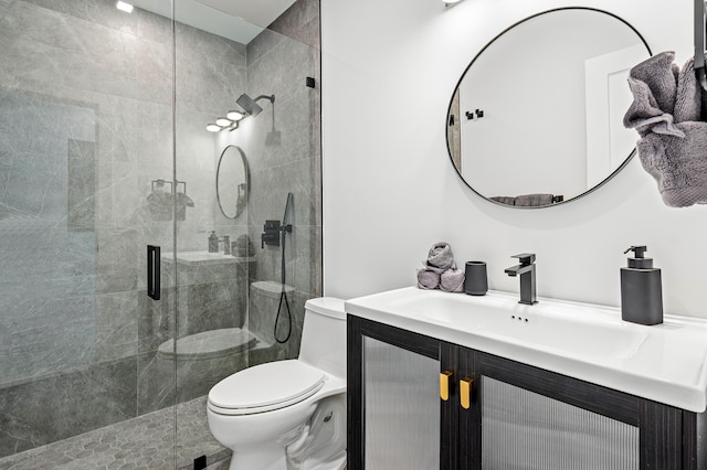 bathroom featuring vanity, toilet, and a shower with shower door