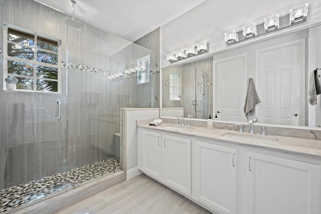 bathroom featuring a shower with door, vanity, and wood-type flooring