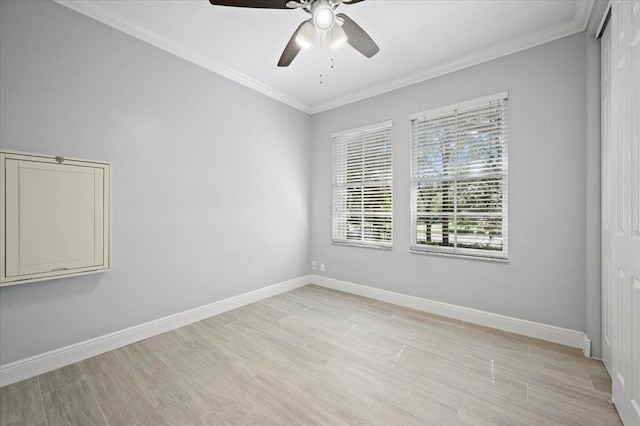 spare room featuring light wood-type flooring, ceiling fan, and ornamental molding