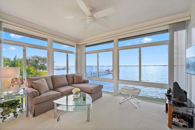 sunroom / solarium featuring a water view, ceiling fan, and a healthy amount of sunlight