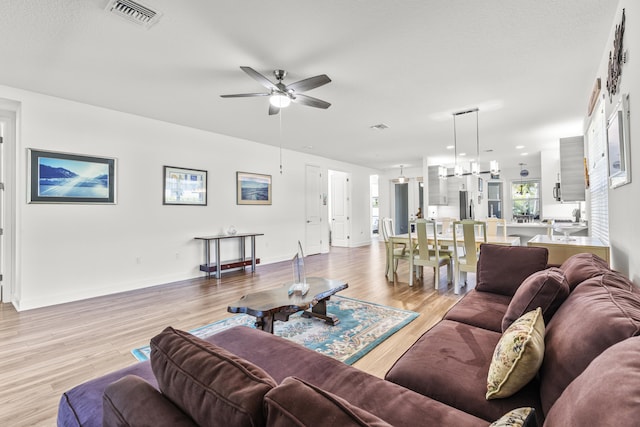 living room with ceiling fan and light wood-type flooring