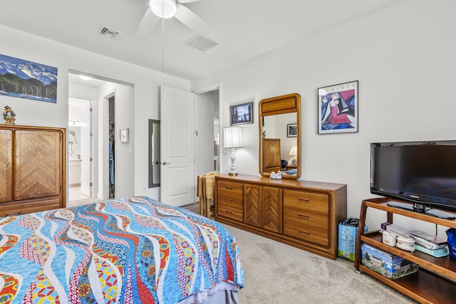 bedroom featuring ceiling fan, light colored carpet, and ensuite bathroom