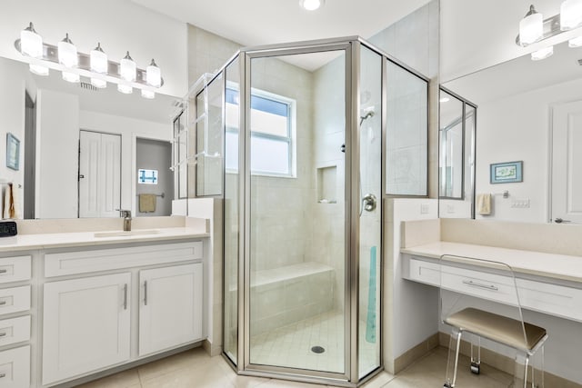 bathroom featuring tile patterned floors, vanity, and a shower with door