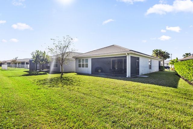 back of property featuring a yard and a sunroom