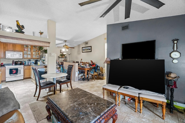 living room with vaulted ceiling, a textured ceiling, and ceiling fan