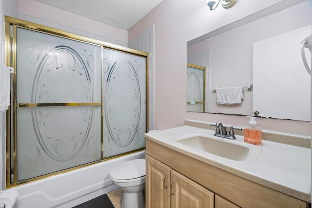 full bathroom featuring vanity, bath / shower combo with glass door, and toilet