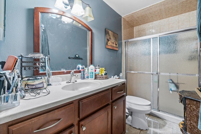 bathroom featuring tile patterned floors, vanity, toilet, and a shower with shower door