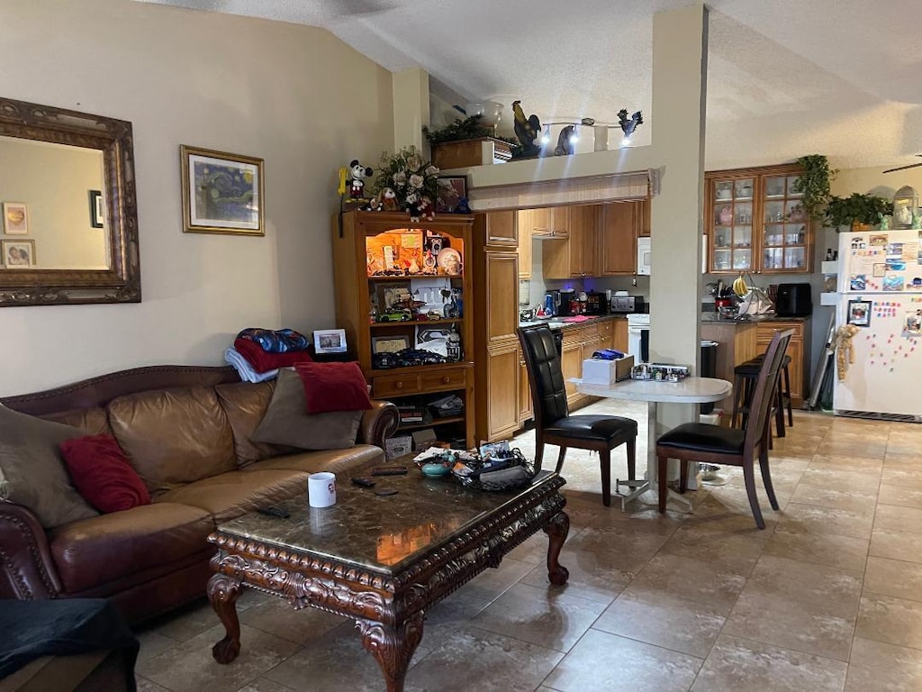 living room with a textured ceiling and vaulted ceiling