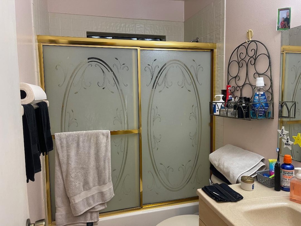 full bathroom with vanity, toilet, and bath / shower combo with glass door