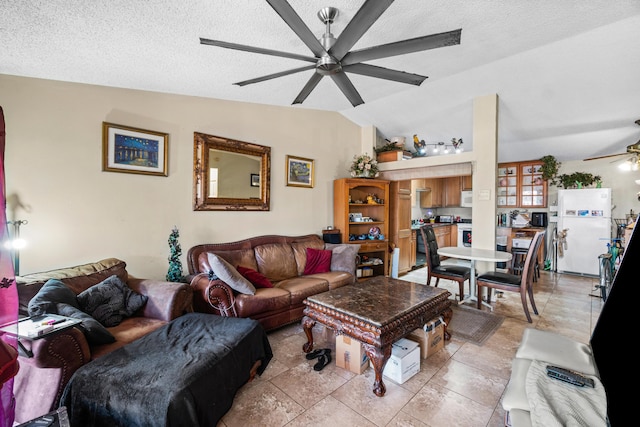 living room with ceiling fan, lofted ceiling, and a textured ceiling