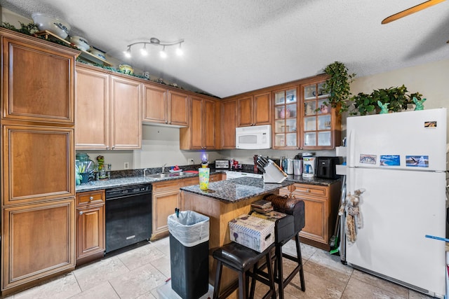 kitchen featuring sink, a breakfast bar area, dark stone counters, a center island, and white appliances