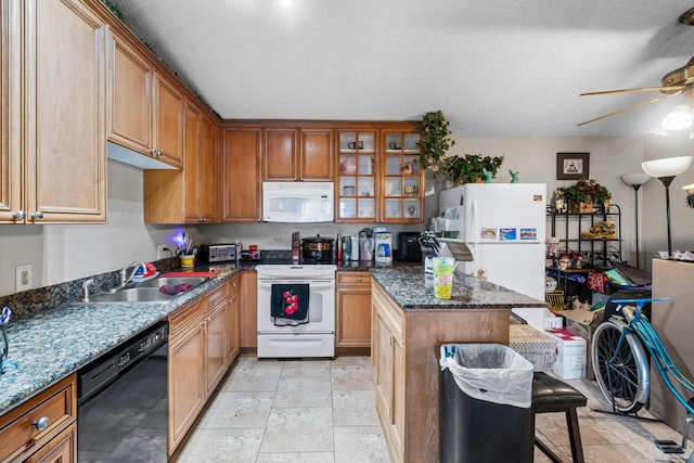 kitchen with a kitchen bar, sink, a textured ceiling, dark stone countertops, and white appliances