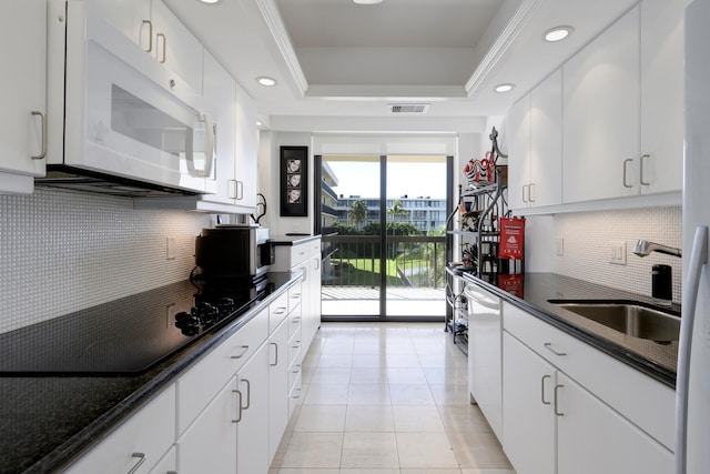 kitchen featuring white cabinetry, sink, a raised ceiling, backsplash, and light tile patterned floors