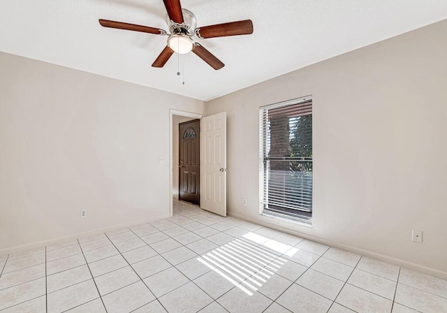 tiled empty room featuring ceiling fan