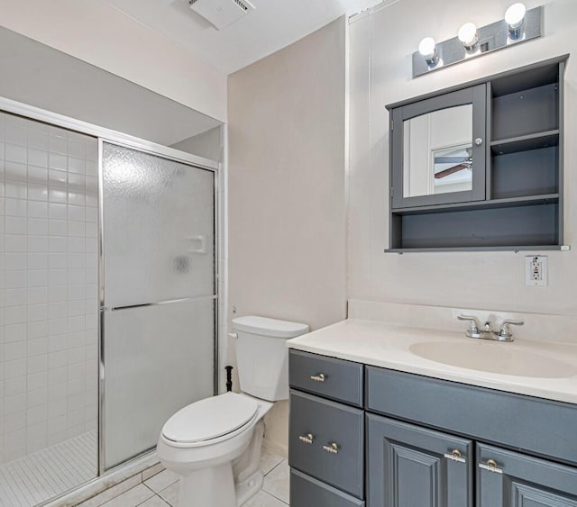 bathroom featuring toilet, vanity, tile patterned floors, and an enclosed shower