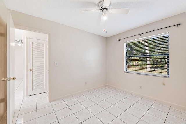 tiled spare room featuring ceiling fan