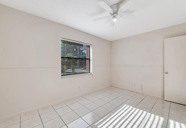 tiled empty room featuring ceiling fan and a textured ceiling