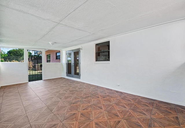 empty room with a textured ceiling and parquet floors