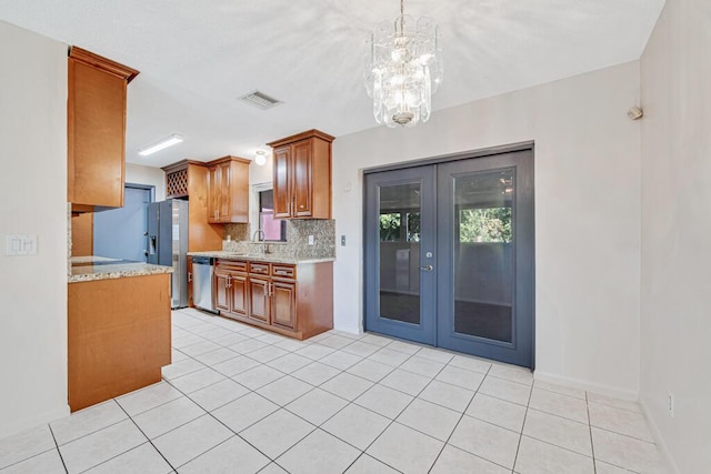 kitchen featuring backsplash, french doors, hanging light fixtures, sink, and appliances with stainless steel finishes