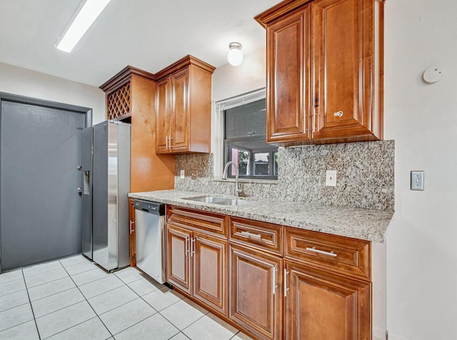 kitchen with dishwasher, sink, tasteful backsplash, light stone counters, and light tile patterned floors