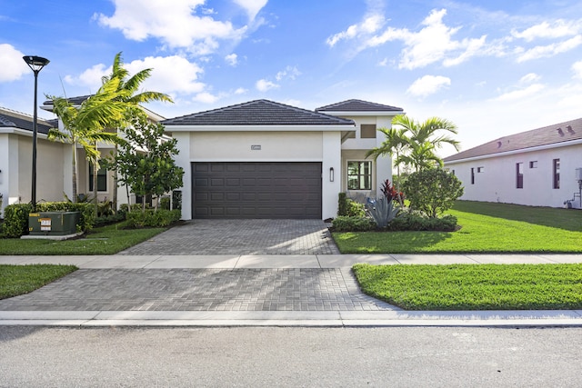 view of front of home with central air condition unit, a front yard, and a garage