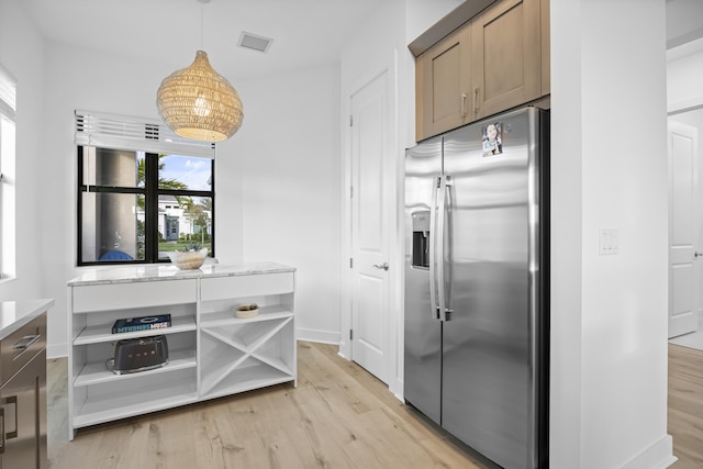 kitchen featuring decorative light fixtures, stainless steel refrigerator with ice dispenser, and light wood-type flooring