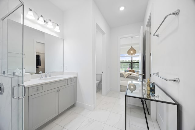 bathroom with vanity, toilet, and a shower with door