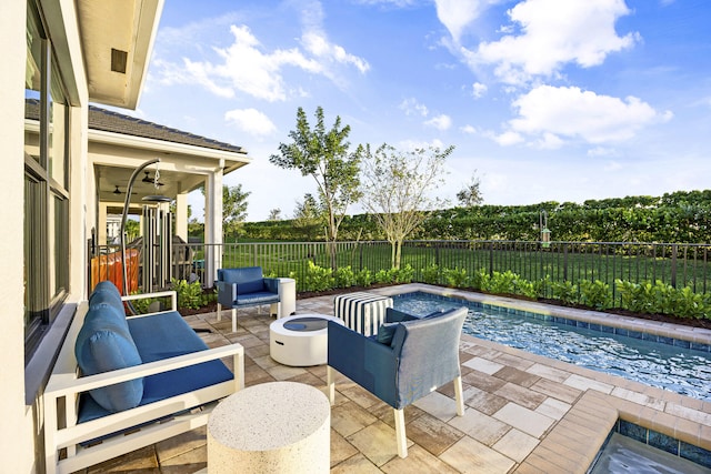 view of patio / terrace with a fenced in pool and an outdoor living space with a fire pit