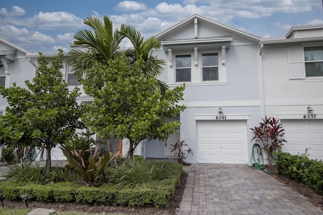 6341 Topsail Dr, West Palm Beach, FL 33413 - view of property featuring an attached garage, stucco siding, and decorative driveway