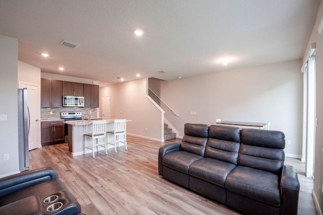 living room featuring light hardwood / wood-style floors and a textured ceiling