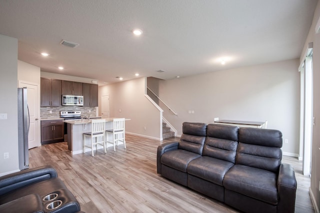 6341 Topsail Dr, West Palm Beach, FL 33413 - living area featuring light wood-style flooring, baseboards, stairway, and recessed lighting