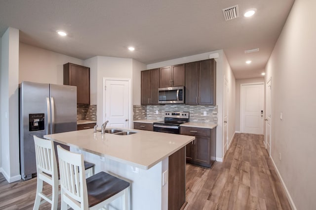 6341 Topsail Dr, West Palm Beach, FL 33413 - kitchen with stainless steel appliances, a sink, decorative backsplash, light wood-style flooring, and recessed lighting
