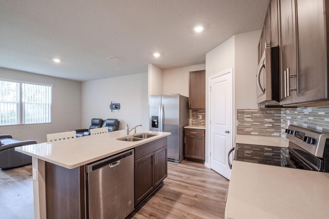 6341 Topsail Dr, West Palm Beach, FL 33413 - kitchen featuring stainless steel appliances, open floor plan, a sink, a center island with sink, and decorative backsplash