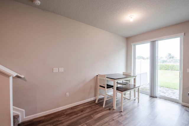 dining area featuring hardwood / wood-style flooring and a textured ceiling