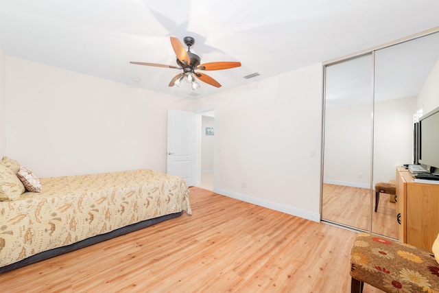 bedroom with ceiling fan, a closet, and hardwood / wood-style flooring