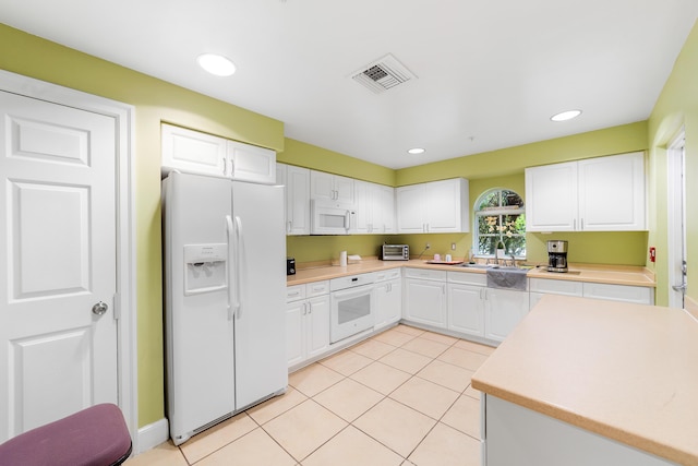 kitchen featuring white cabinets, light tile patterned floors, white appliances, and sink