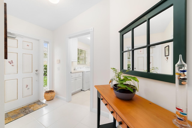 entrance foyer featuring light tile patterned flooring, lofted ceiling, and washer / clothes dryer