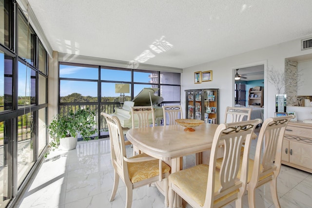 dining area with floor to ceiling windows, ceiling fan, and a textured ceiling