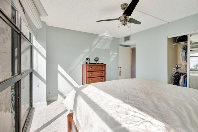 bedroom with ceiling fan, a textured ceiling, and a closet