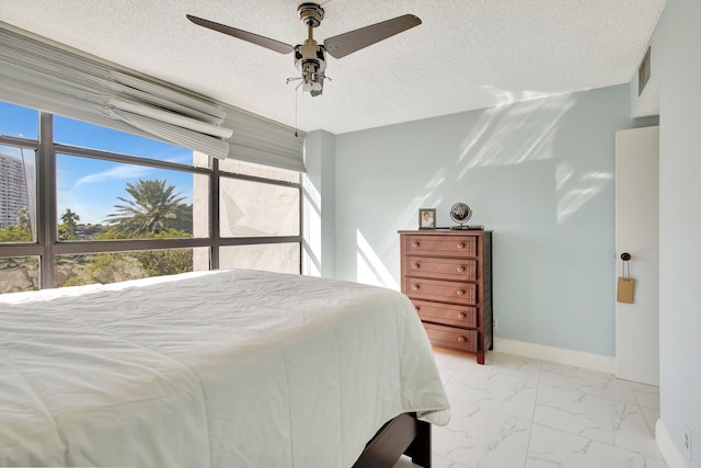 bedroom featuring ceiling fan and a textured ceiling