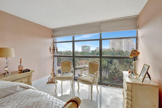 bedroom featuring multiple windows, floor to ceiling windows, and a textured ceiling