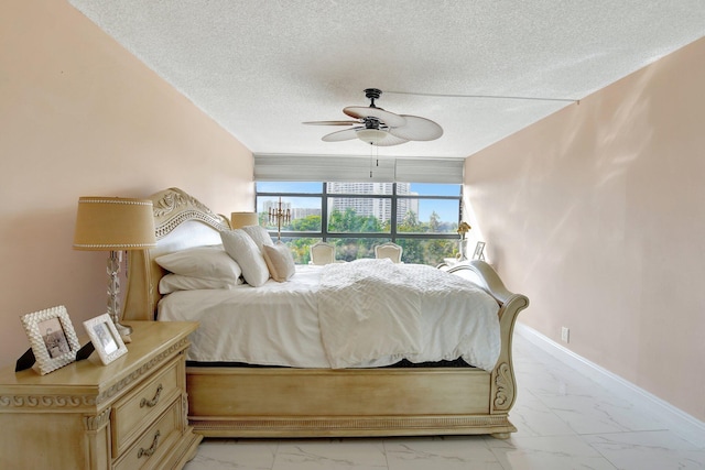 bedroom with a textured ceiling and ceiling fan