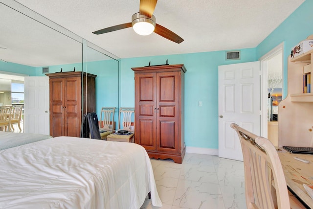 bedroom featuring ceiling fan and a textured ceiling