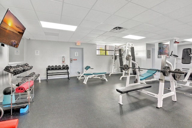 workout area with a paneled ceiling and electric panel